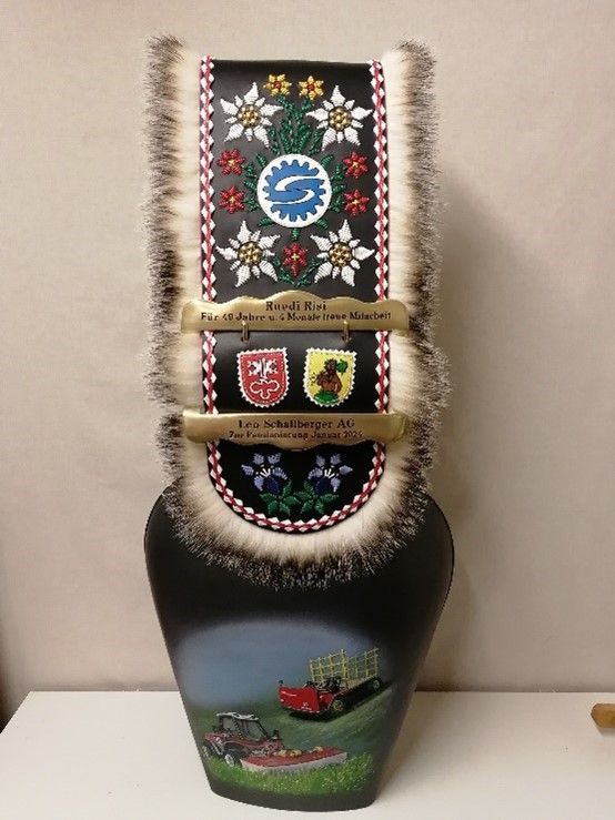 Auf einem Tisch steht eine schwarze Vase mit einem Gemälde darauf.