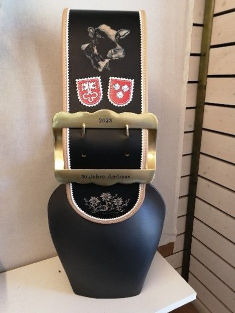Eine schwarze Glocke mit dem Bild einer Kuh darauf