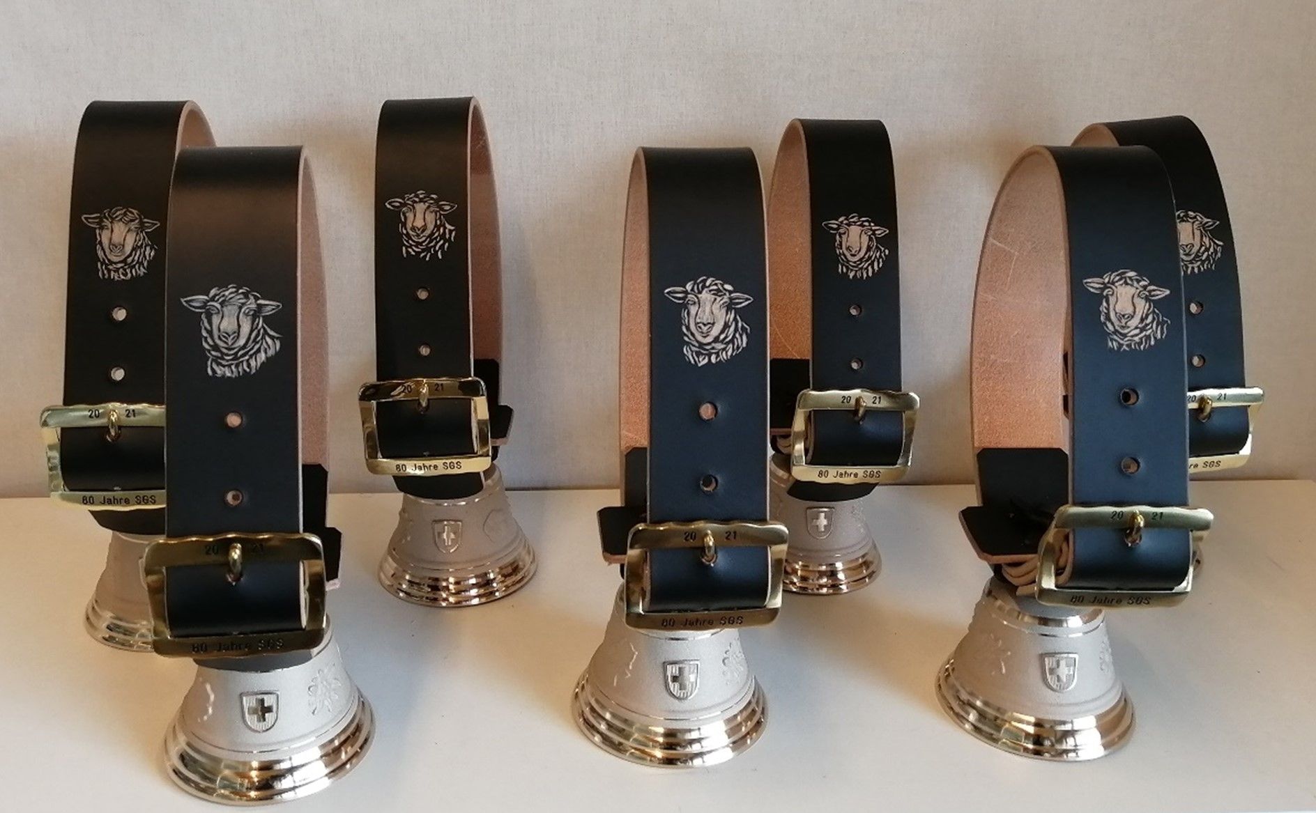 Eine Reihe schwarzer Gürtel mit goldenen Schnallen und Glöckchen