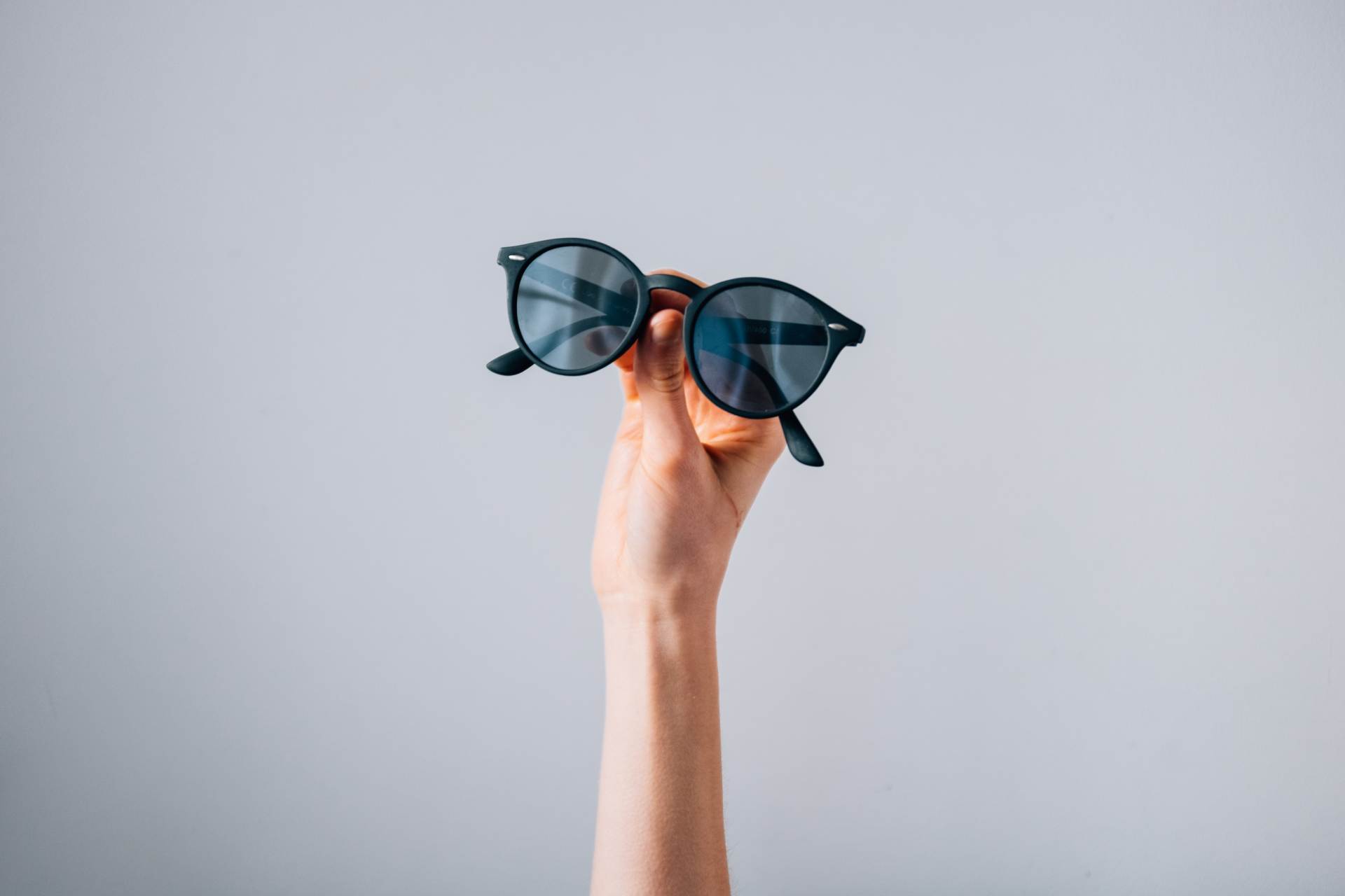 Sonnenbrille in Hand