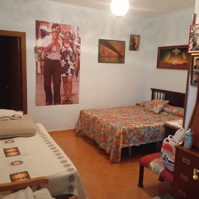 Un dormitorio con una foto de un hombre y una mujer en la pared encima de la cama.