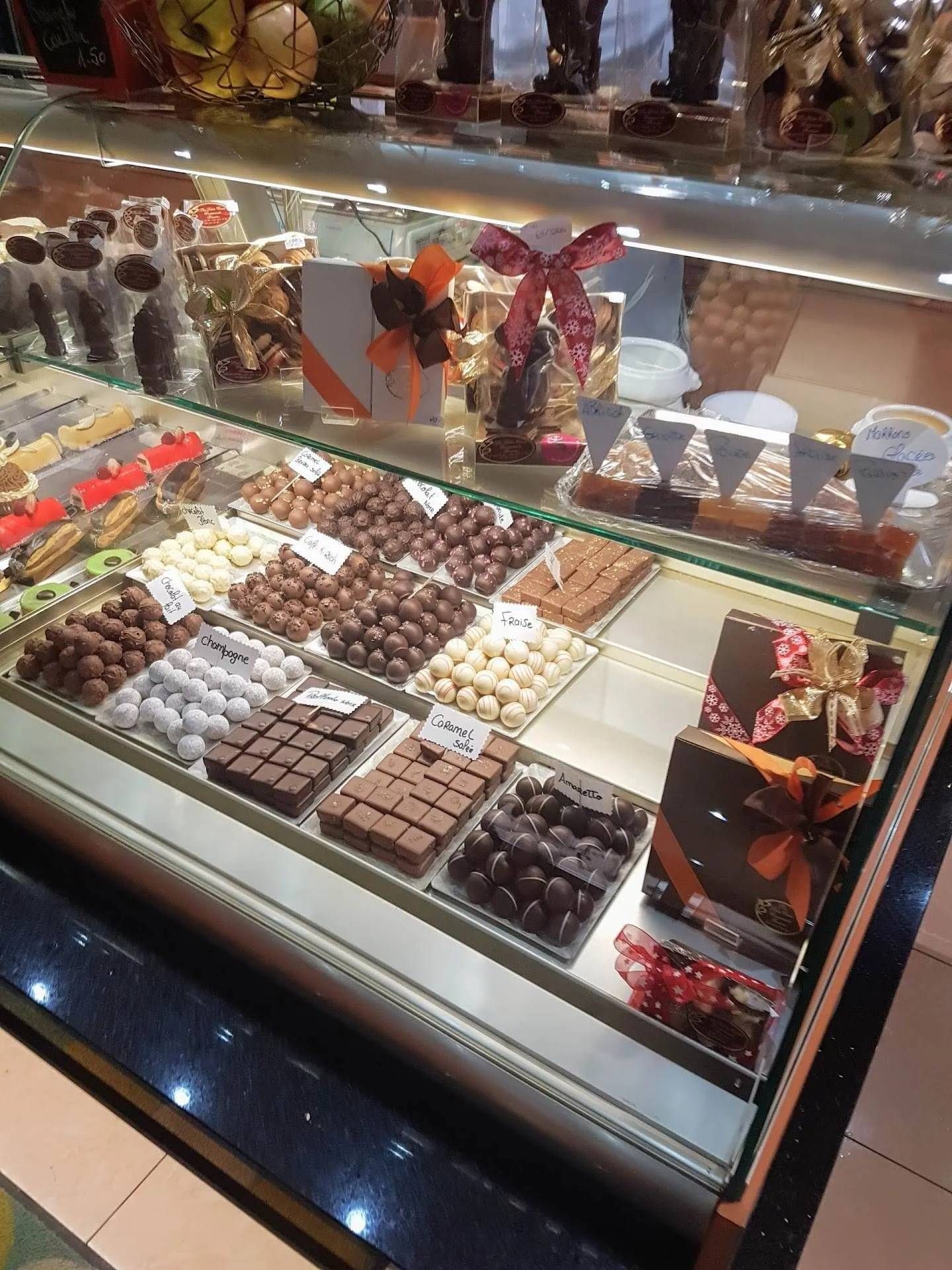 Vitrine en verre présentant un assortiment de chocolats et de bonbons dans une boutique