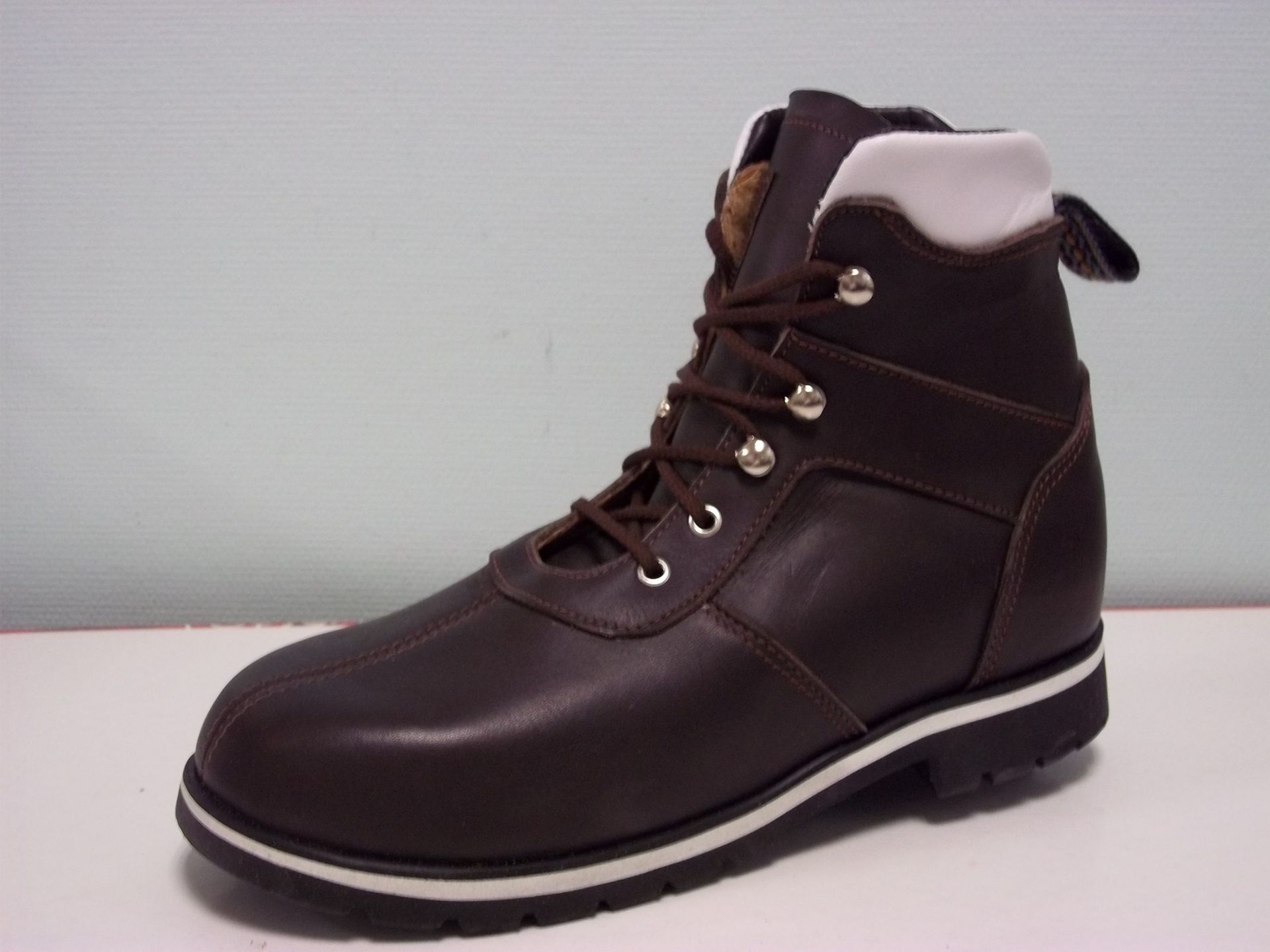 Bottes d'hiver marron foncé à lacets avec col en fourrure blanche sur fond gris uni