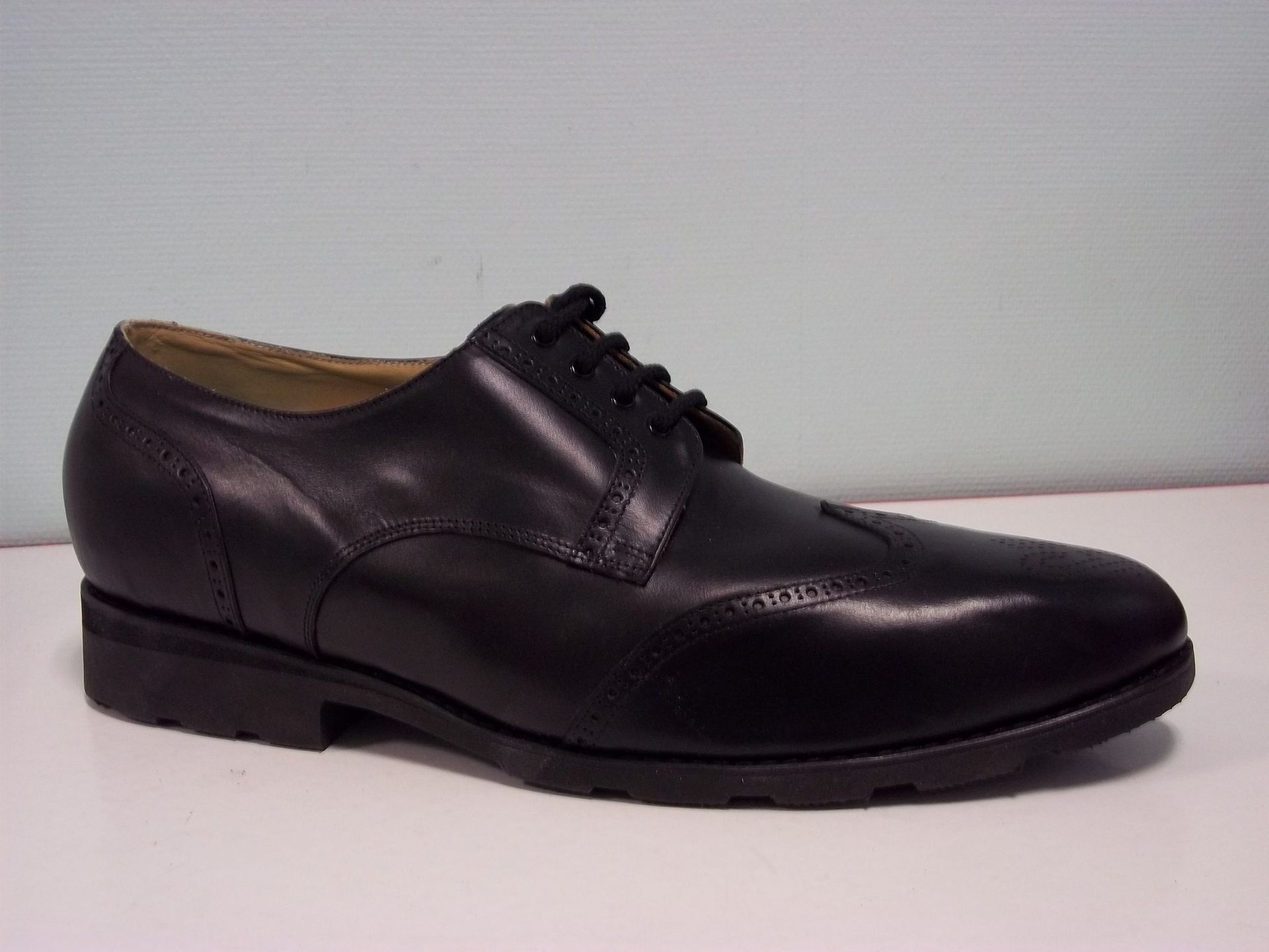 Chaussure habillée en cuir noir vue de profil sur fond uni