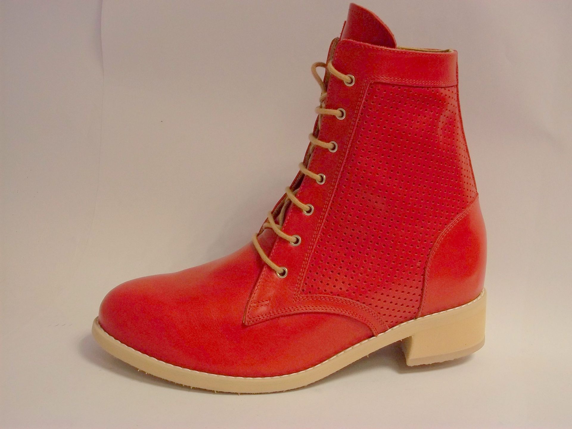 Bottine rouge à lacets avec semelle beige sur fond uni