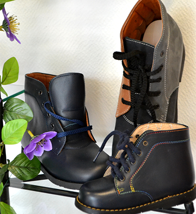 Trois bottes en cuir noir à fleurs violettes sur fond blanc