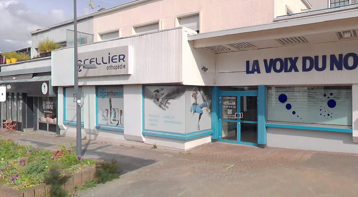 Un groupe de personnes se tient à l'extérieur, devant un bâtiment ; certaines portent des chemises blanches.