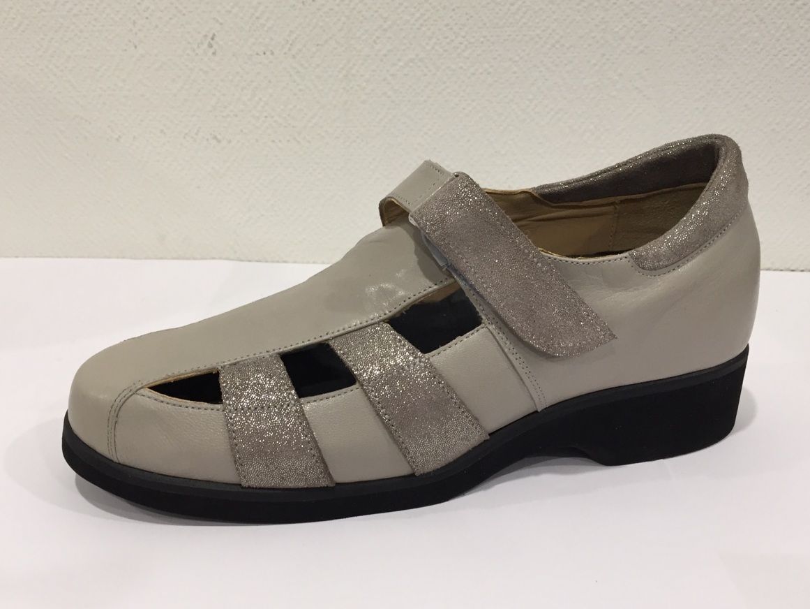 Chaussure Mary Jane argentée pour femme, avec brides à paillettes et semelle noire sur fond blanc.