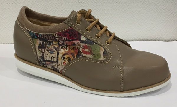 Chaussure à lacets en cuir marron avec empiècement latéral à motifs sur fond blanc