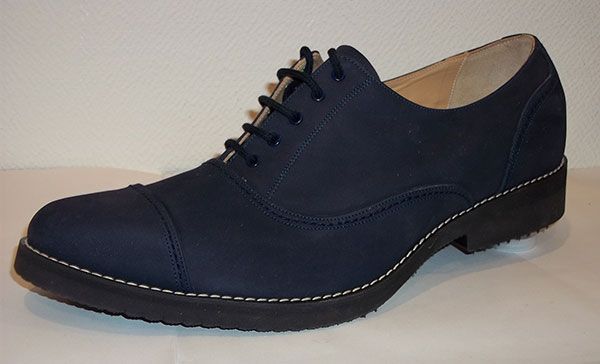 Chaussure habillée bleu marine à lacets et semelle noire, vue de profil.