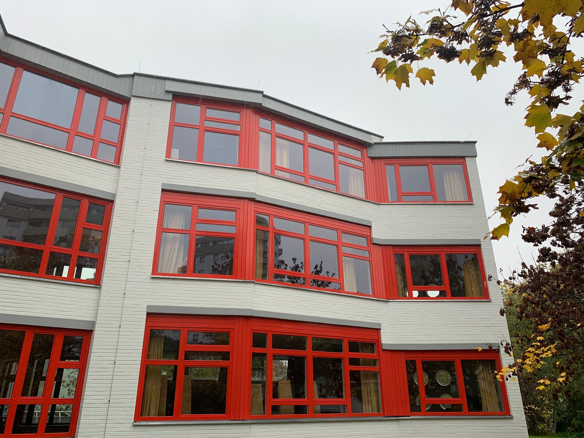 Weißes Gebäude mit roten Fenstern