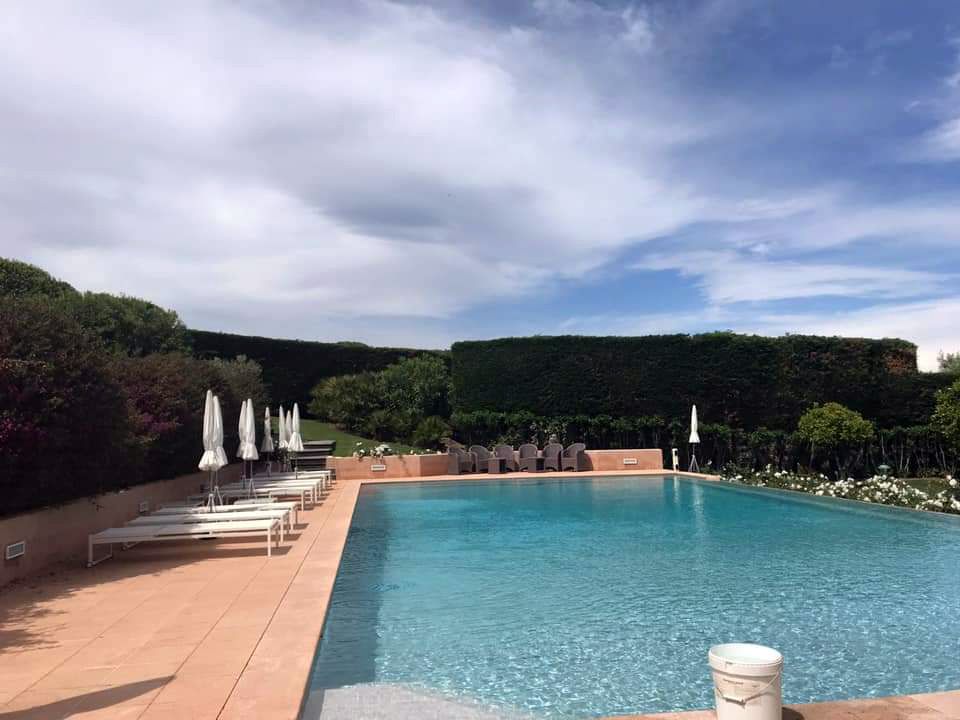 Terrasse en bois autour d'une piscine avec des transats