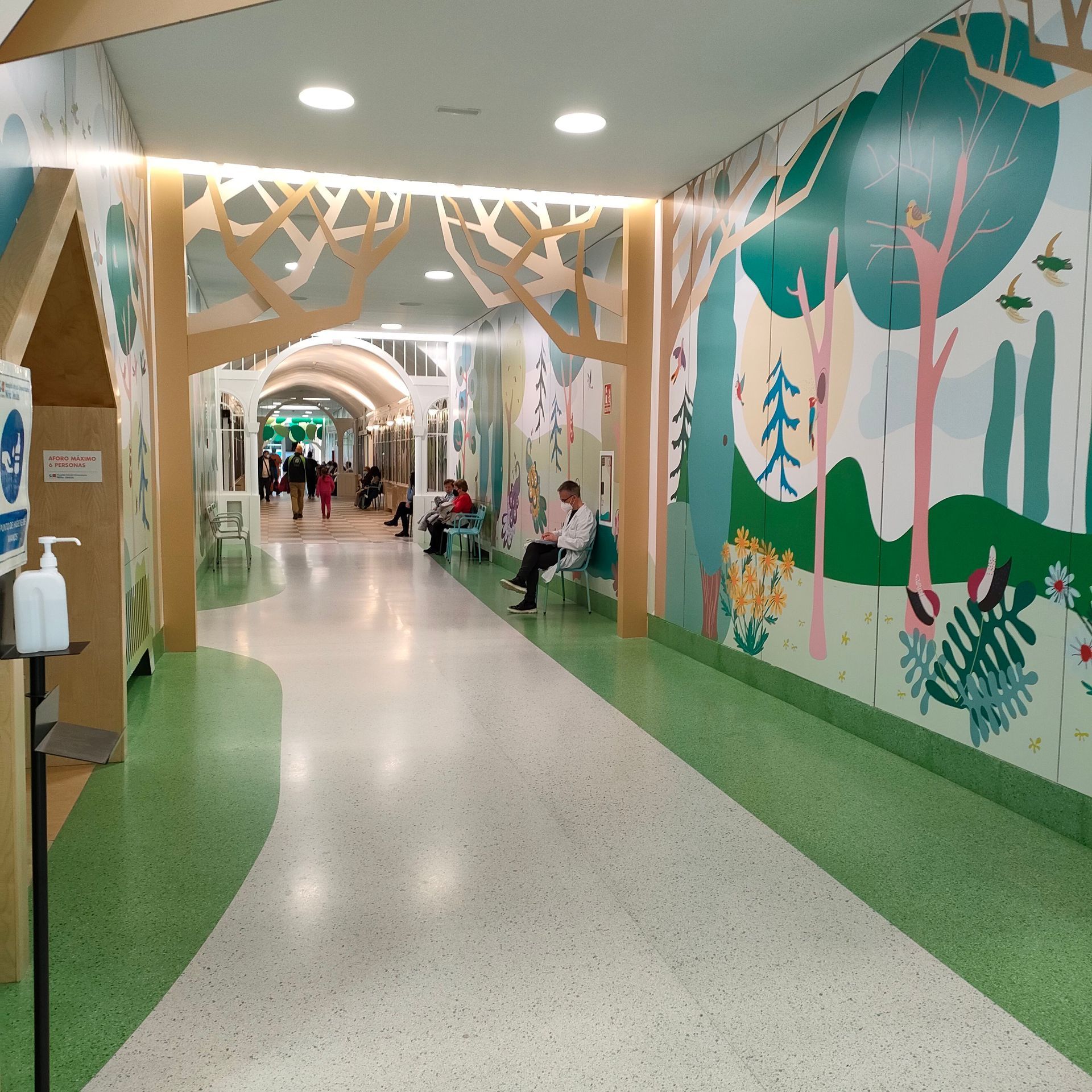 Un pasillo con una pintura de árboles en la pared.