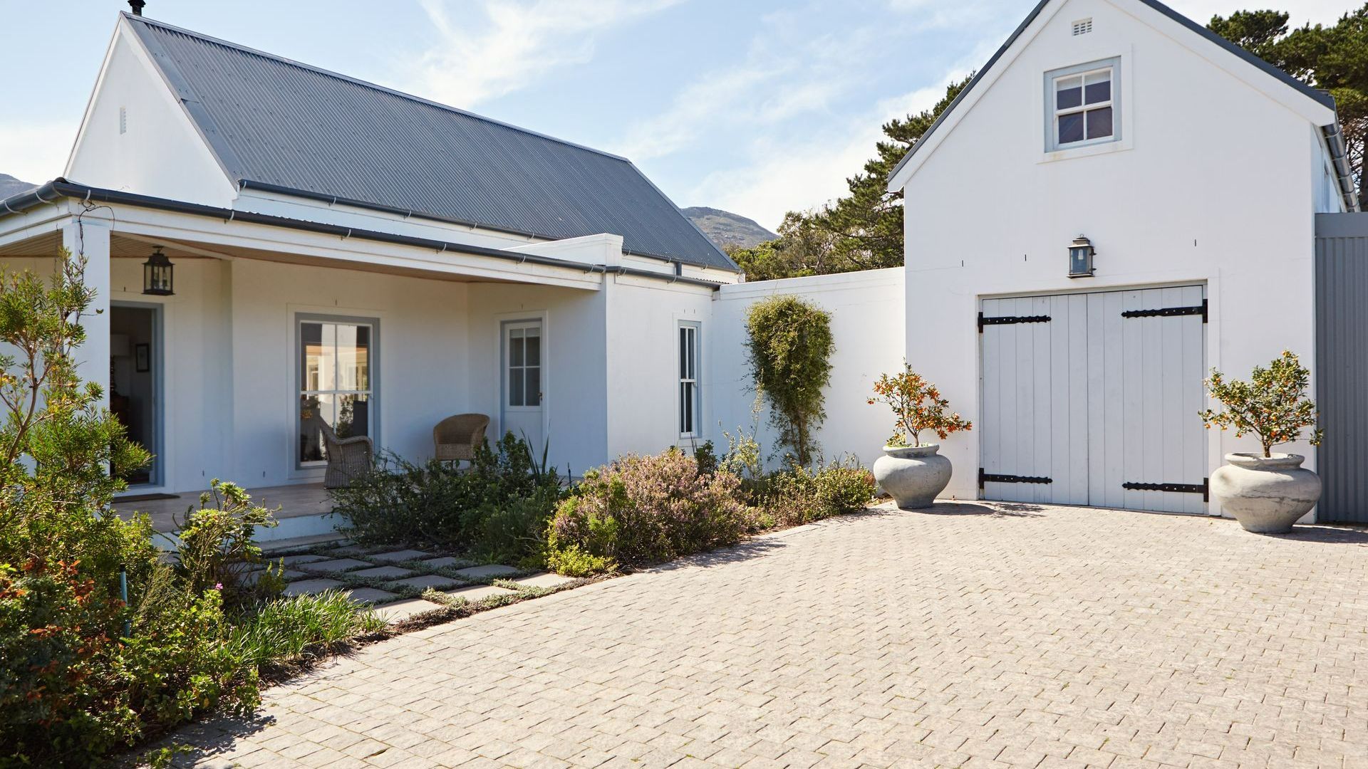 Cour en pavés devant le garage et le côté de la maison