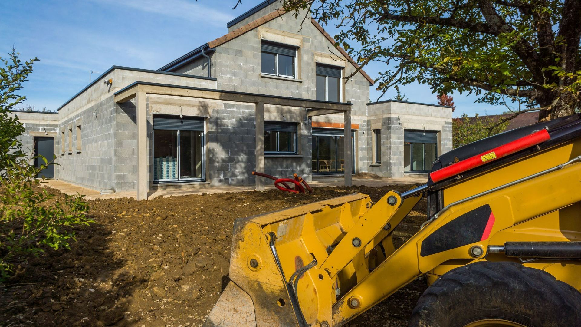 Remblaiement autour de la maison avec une tractopelle