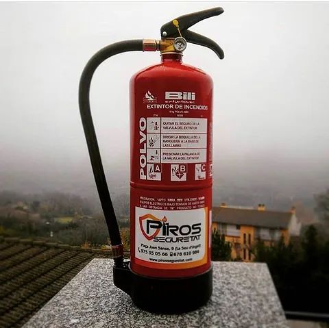 Un extintor rojo está sobre un tejado.