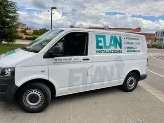 Una camioneta blanca con la palabra Elan en el costado está estacionada en un estacionamiento.