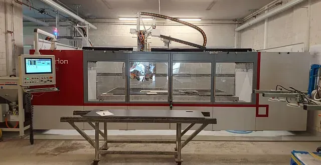 In einem Raum steht neben einem Tisch eine große Maschine.