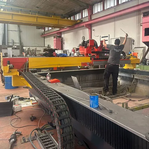 Ein Mann arbeitet in einer Fabrik an einer Maschine.