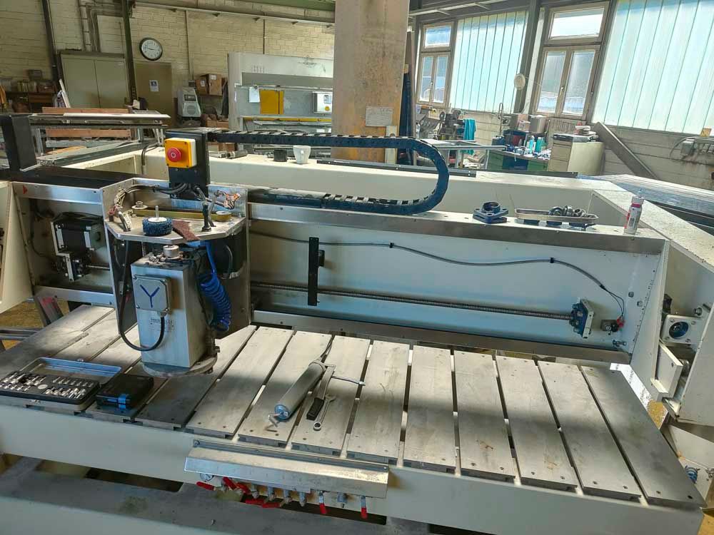 In einer Fabrik steht eine Maschine auf einem Holztisch.