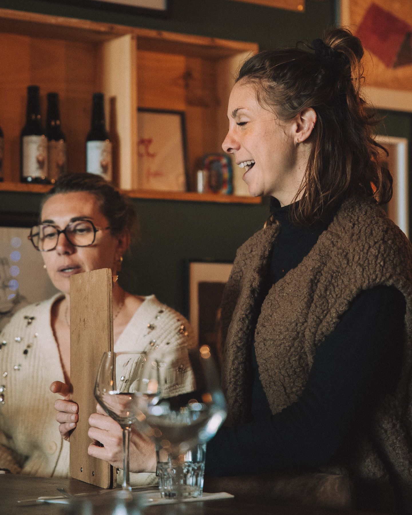 Serveuse du restaurant parlant à une cliente lisant la carte