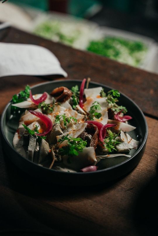 Assiette de poisson avec de la verdure et des pickles d'oignon rouge
