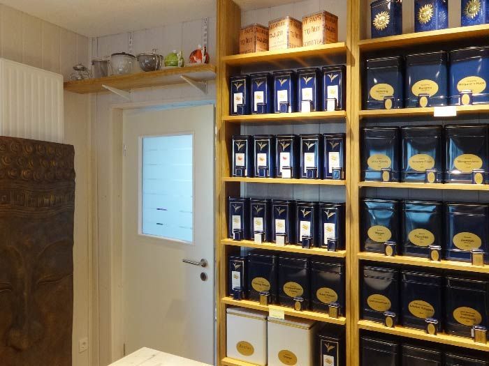 Eine Reihe von Regalen mit blauen Schachteln Tee