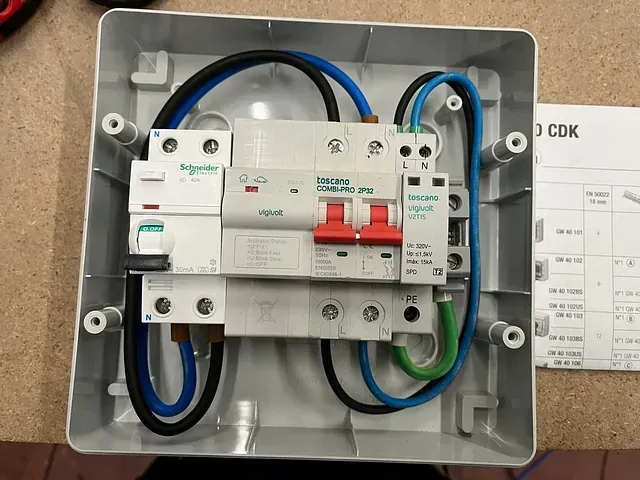 Una caja con equipo eléctrico dentro y un trozo de papel que dice CDK.