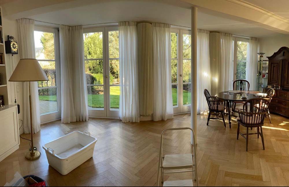 Ein Wohnzimmer mit einem Tisch, Stühlen und einer Lampe.