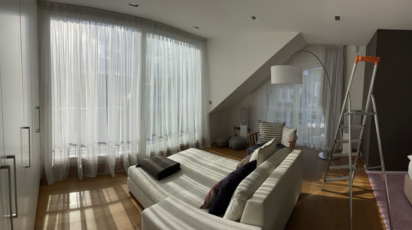 Ein Wohnzimmer mit einem weißen Sofa und einer Leiter