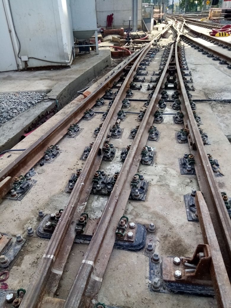 Vías ferroviarias que se bifurcan en múltiples direcciones sobre una superficie de hormigón.