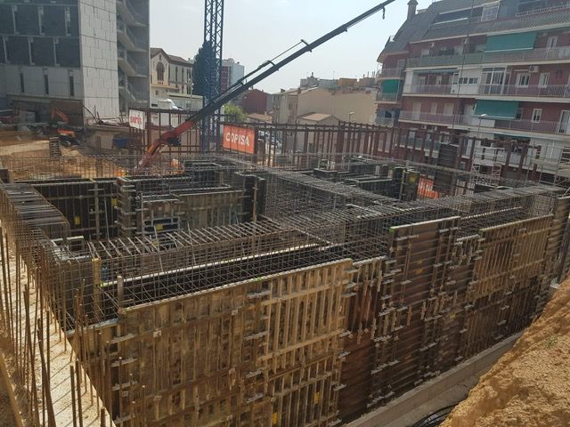 Obra con estructura de hormigón armado. Encofrado de acero y madera en una excavación profunda.