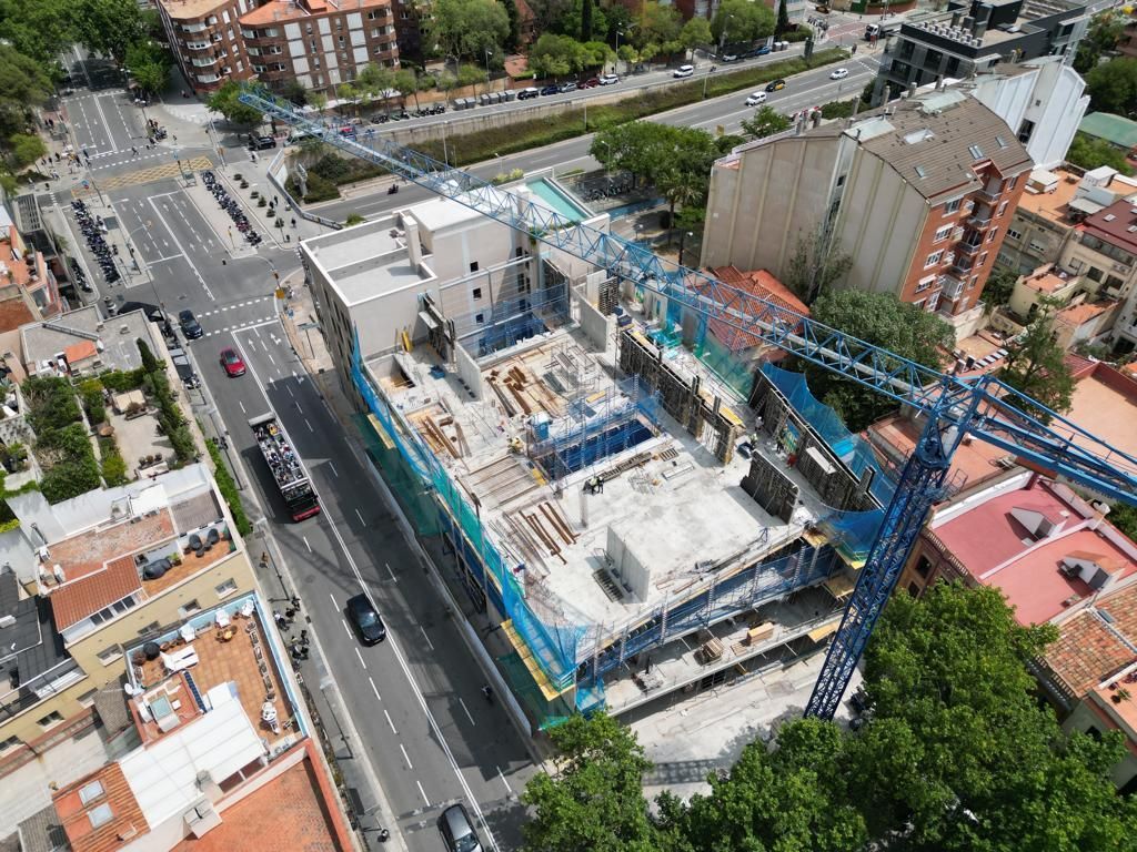 Sitio de construcción con grúas rodeado de edificios y carreteras.