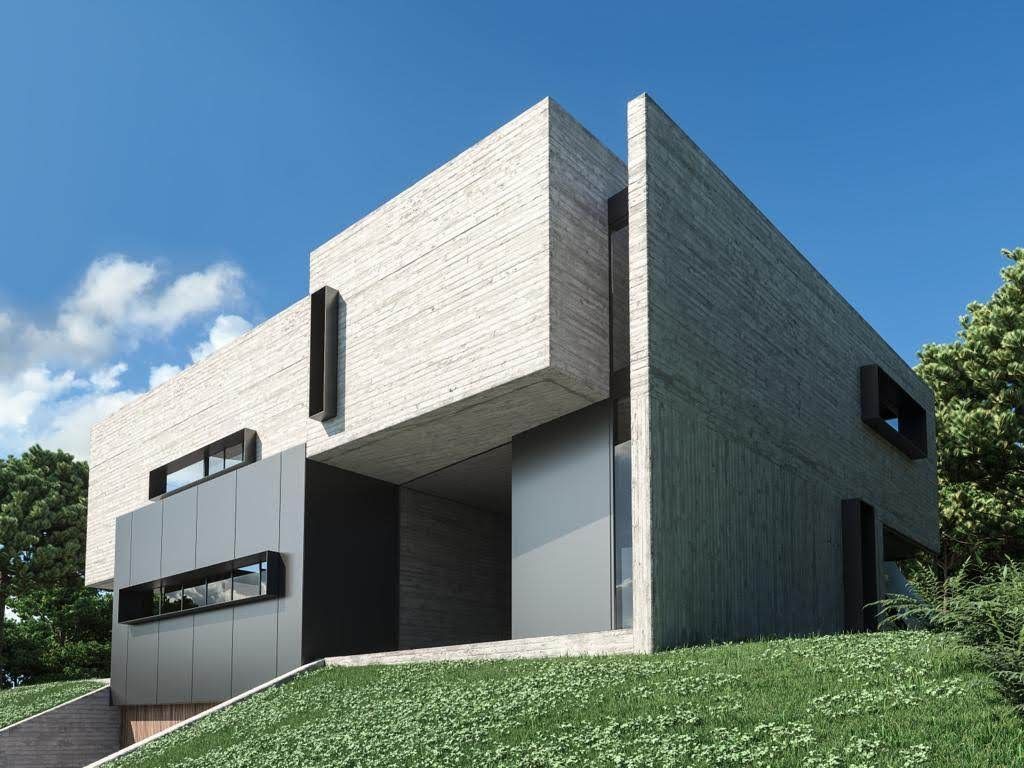 Moderna casa de hormigón en una ladera, con grandes ventanales y un patio con césped.