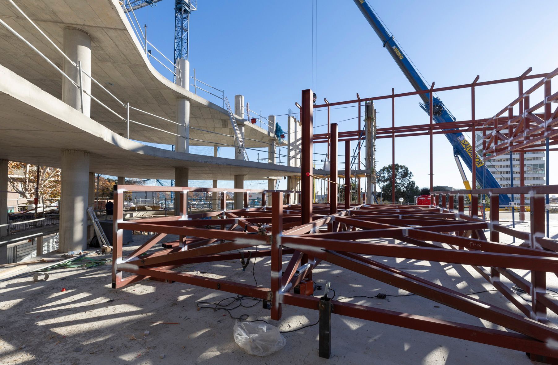 Sitio de construcción, estructura de acero con estructura de hormigón curvado, cielo azul.
