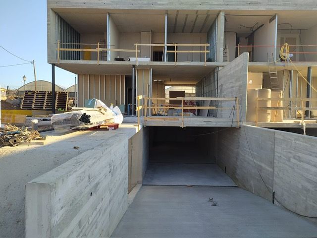 Edificio de hormigón en construcción con entrada de garaje.