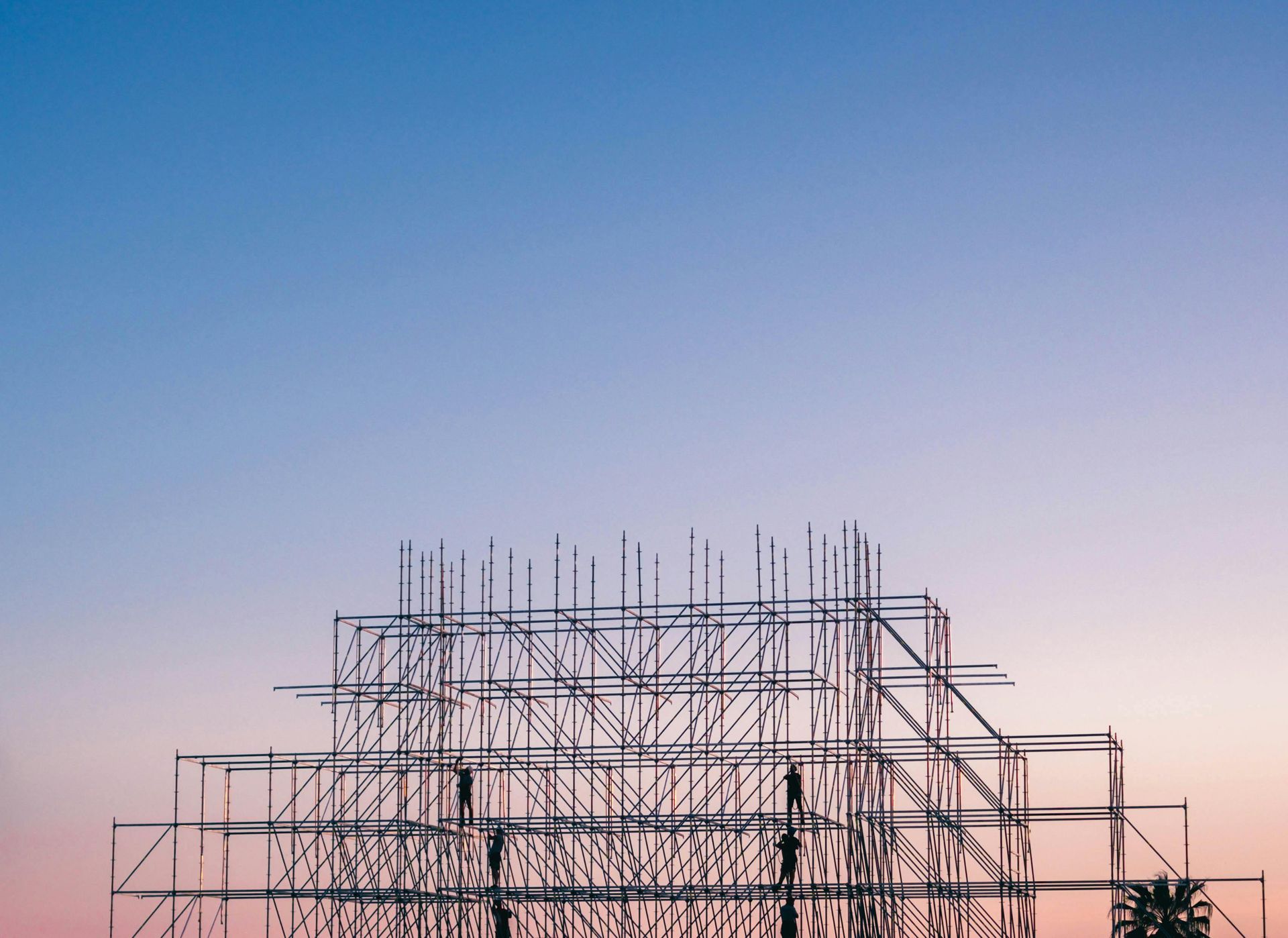 Estructura de andamios contra un cielo degradado de color rosa y azul.