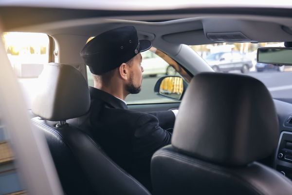 Blick von hinten auf einen Chauffeur in einer Limousine