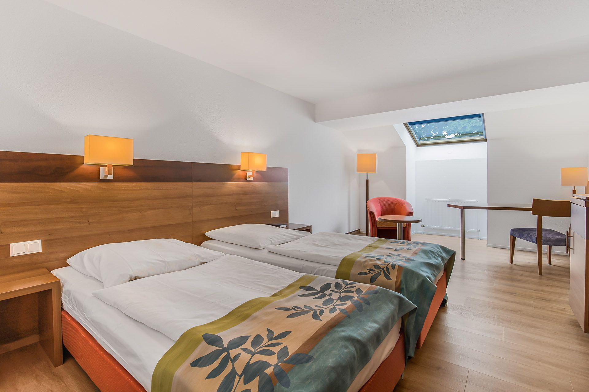 Doppelzimmer mit zwei Einzelbetten, Holzkopfteil und Oberlicht.