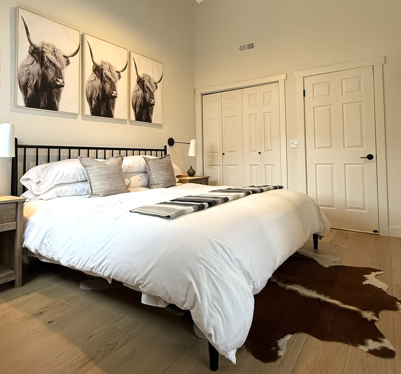 Cozy living room with fireplace, built-in shelves, armchairs, and open kitchen with light wood cabinets.