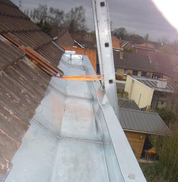 Une gouttière grise en rénovation.
