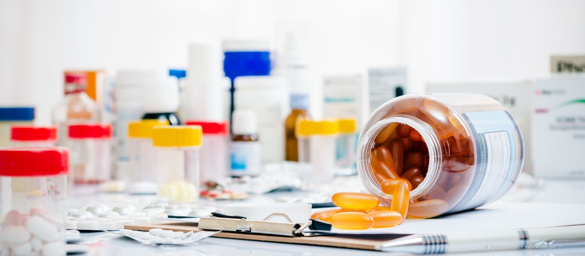 Ein Tisch voller verschiedener Medizinflaschen und verschütteter Kapseln, der an eine Apotheke oder einen medizinischen Ort erinnert.