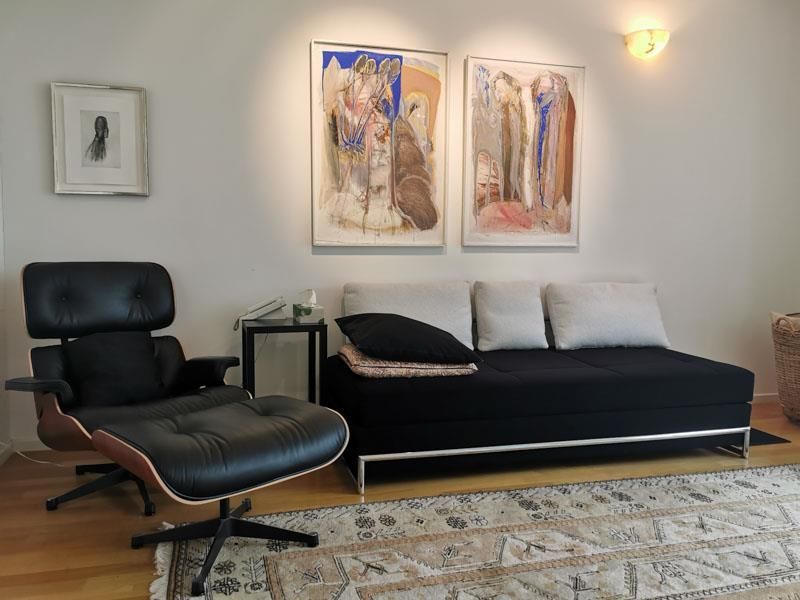 Ein Wohnzimmer mit einer schwarzen Couch und einem schwarzen Sessel