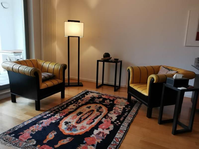 Ein Wohnzimmer mit zwei Stühlen und einem Teppich