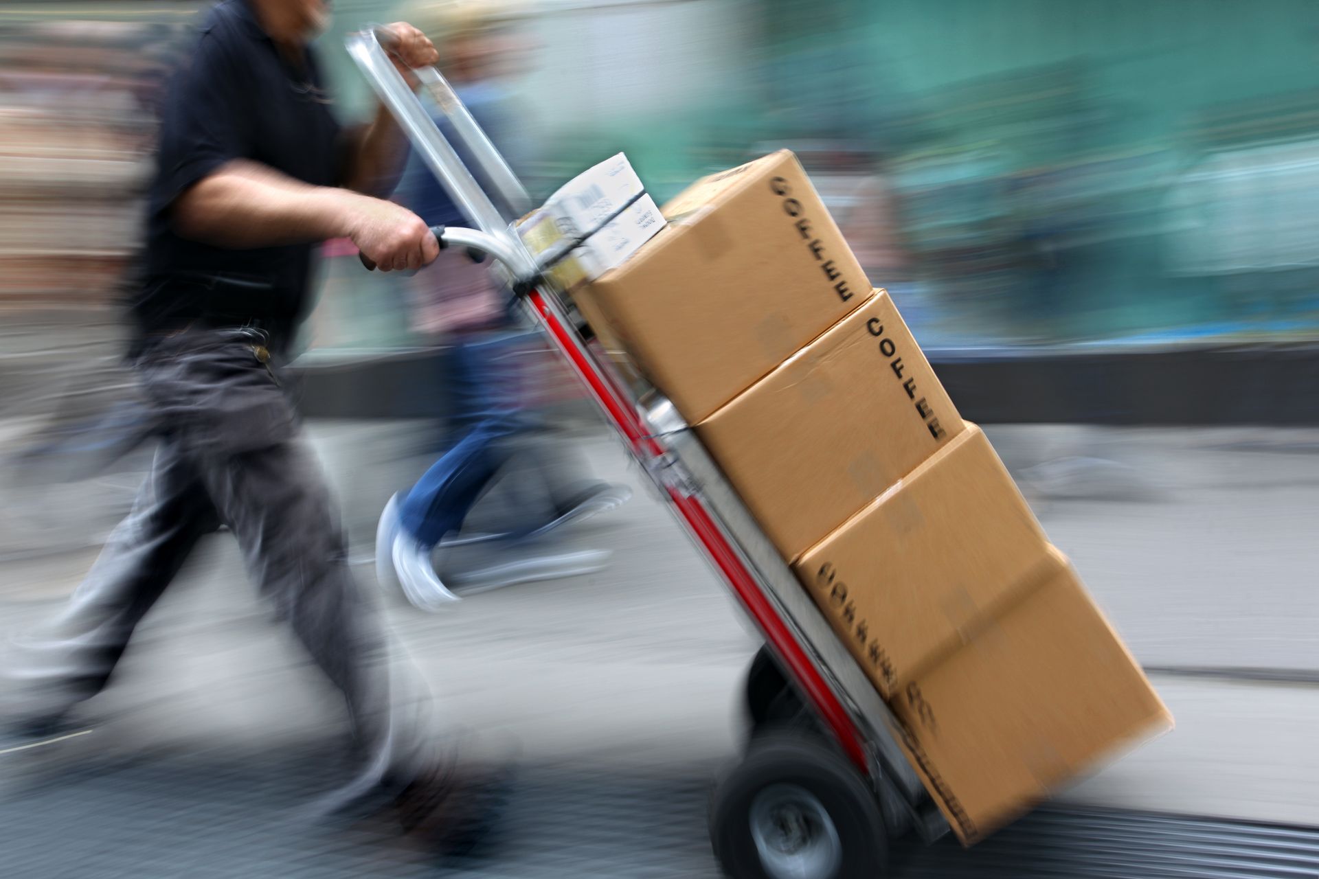 Un homme transporte des colis sur un diable