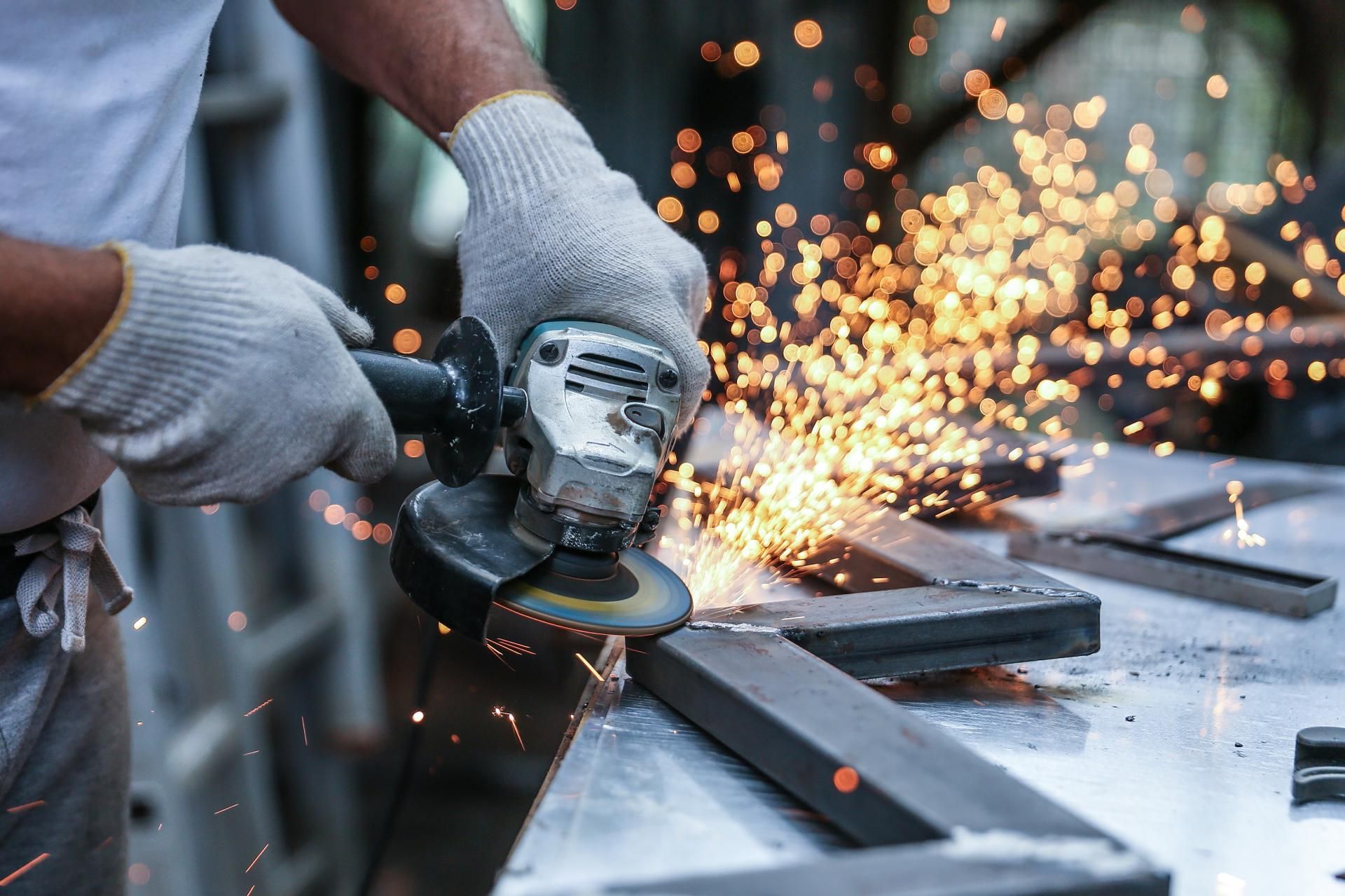 Metallbau Teichrib UG - Person schneidet Stahlkonstruktion, Funken sprühen