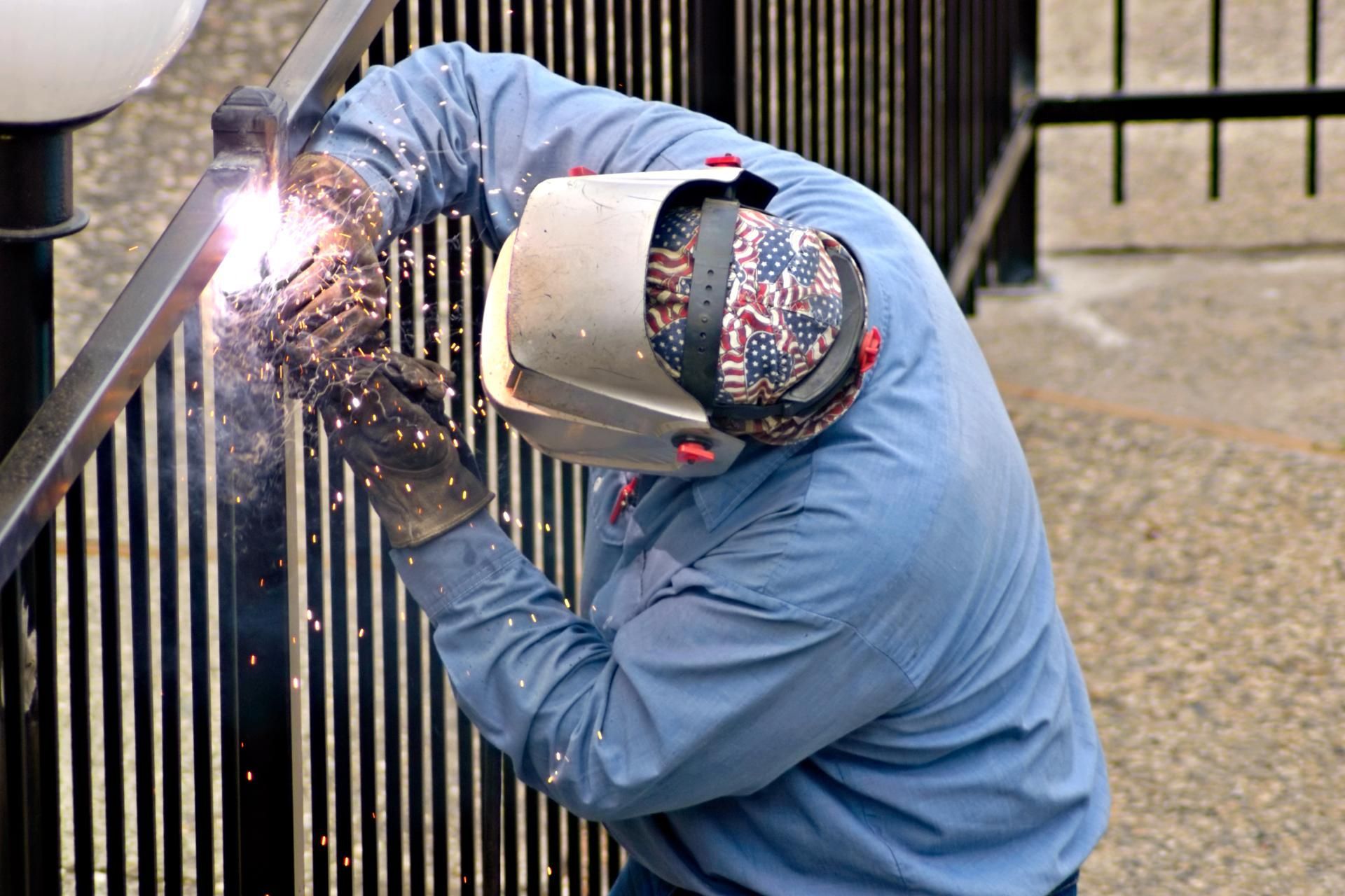 Metallbau Teichrib UG - Mann mit Schweißgerät bearbeitet ein Treppengeländer