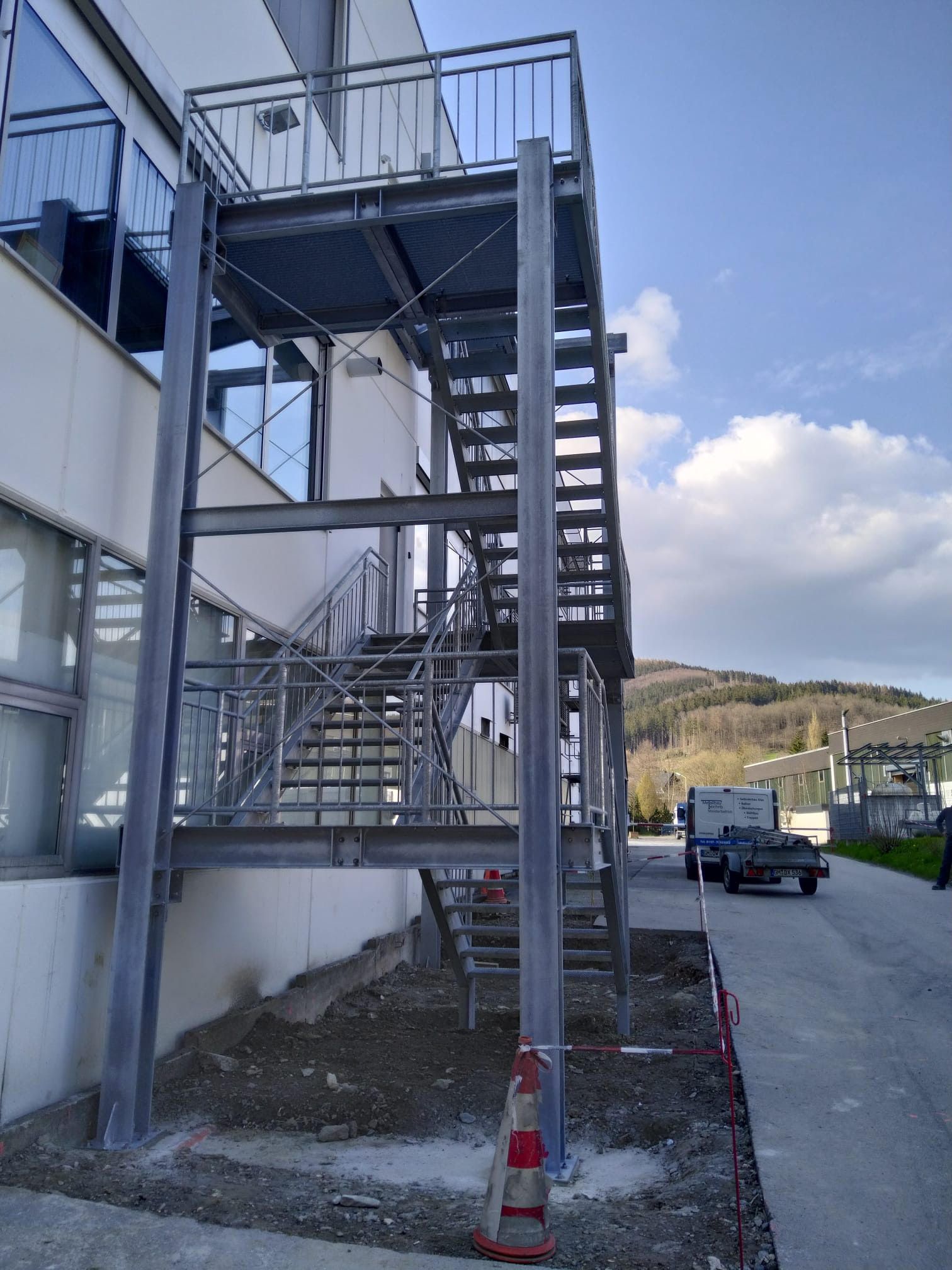 Eine Metalltreppe mit Geländer befindet sich außerhalb eines Gebäudes