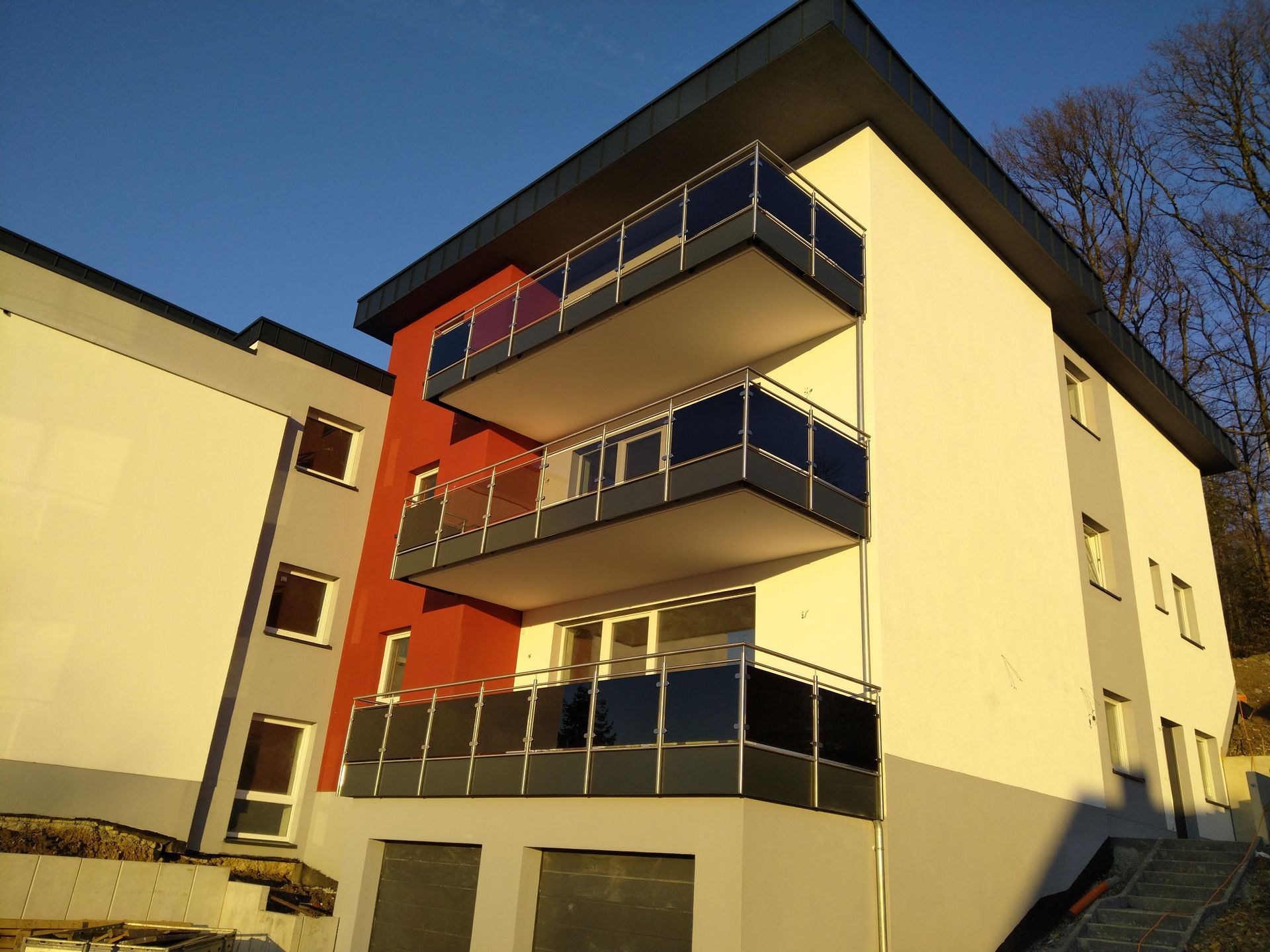 Ein Gebäude mit drei Balkonen und einem blauen Himmel im Hintergrund