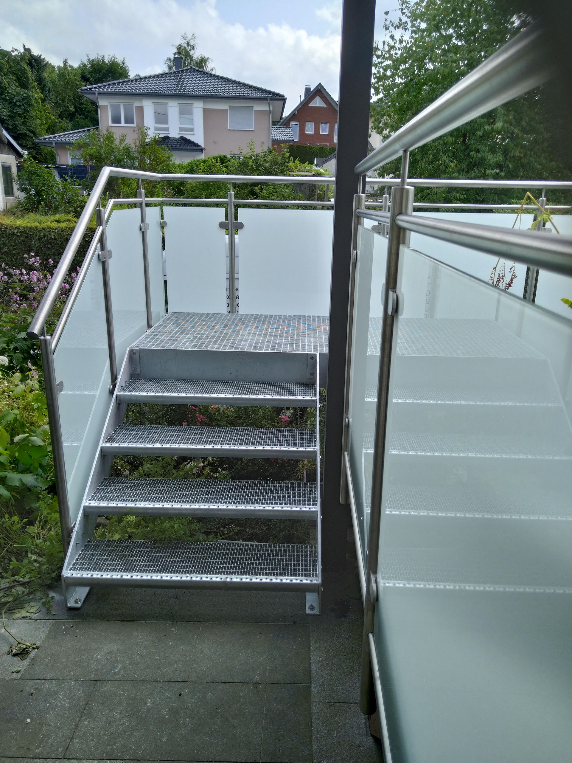Eine Treppe, die zu einem Balkon mit Glasgeländer führt